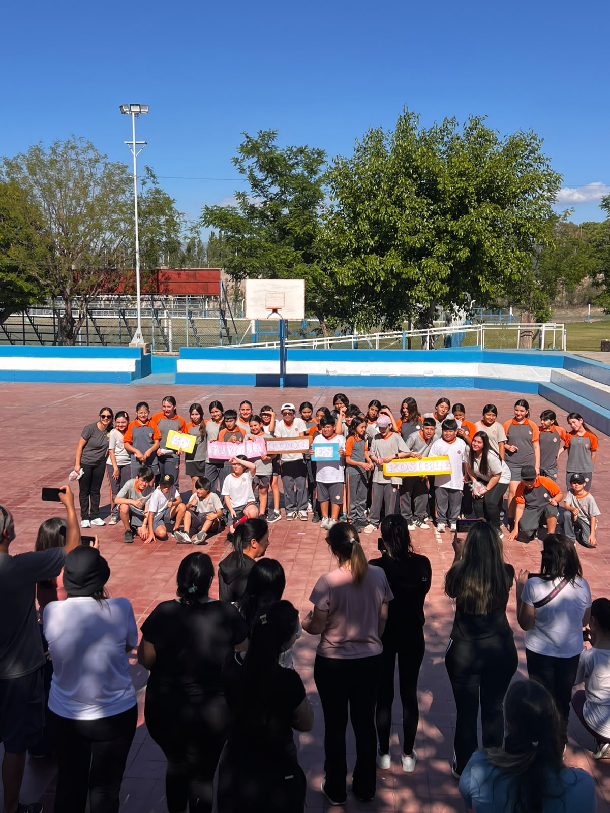 Foto grupal en la cancha, con carteles de la jornada.